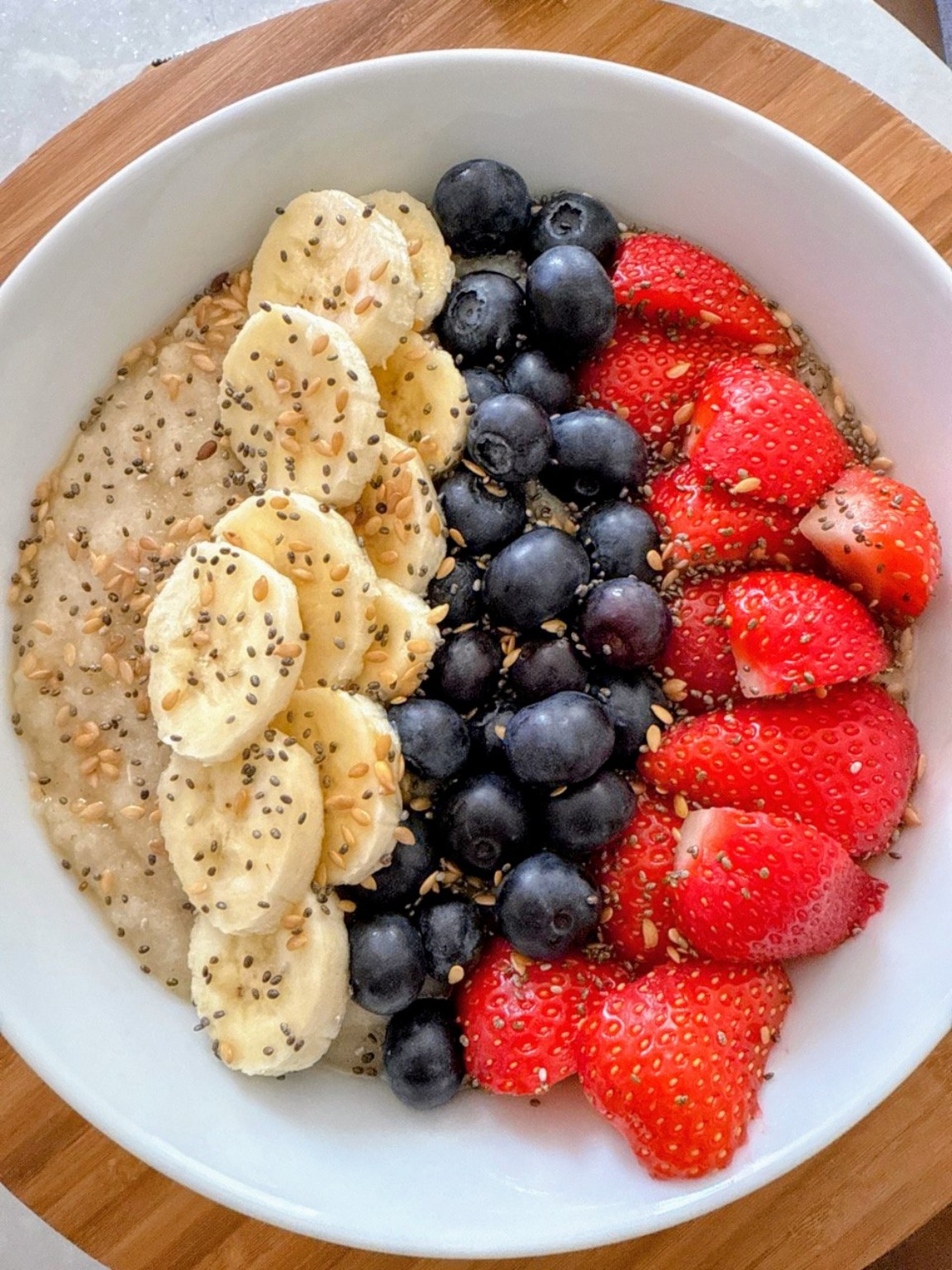 A bowl of Ogi served with fruit and seeds